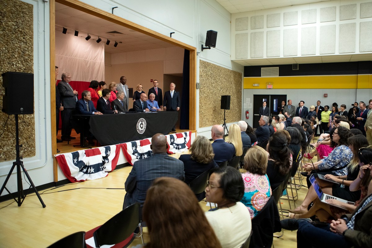 Lt. Gov. Dan Patrick (front, second from left), Gov. Greg Abbott and House Speaker Dennis Bonnen speak at a press conference on the $11.6 billion school finance reform bill. Abbott signed the bill into law Tuesday at Parmer Lane Elementary School in Austin.