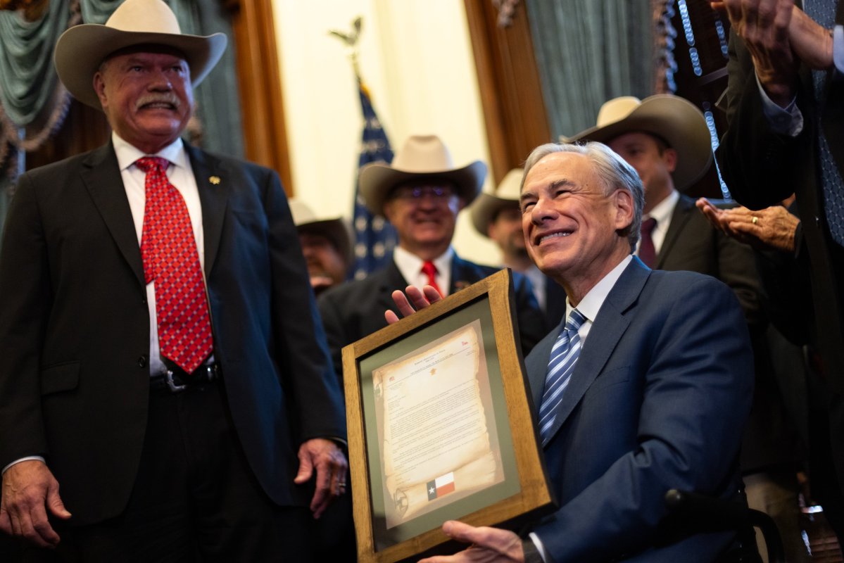 Gov. Greg Abbott poses with a framed letter from the Sheriffs Association of Texas at the Texas Capitol in Austin on Wednesday, March 20, 2024.