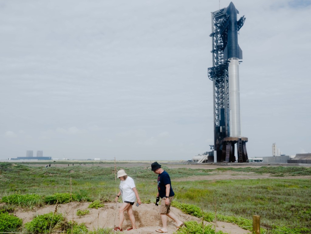 A couple walks along the dunes at Boca Chica beach next to the SpaceX launchpad on Aug. 24, 2025.