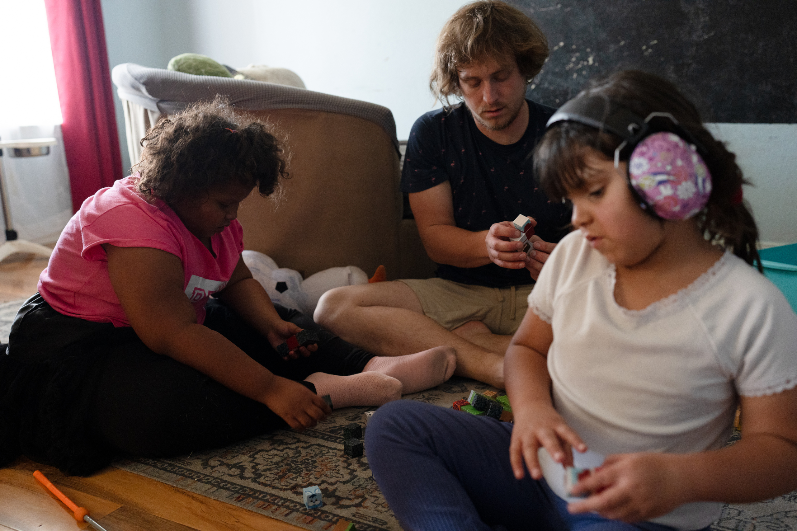 Seven-year-old Freyja Radtke, who suffers from Bardet-Biedl syndrome, a condition which causes excessive weight gain and hormonal imbalances, plays with her dad Sean Radtke and her sister, Morrigan, 5, at their home on Saturday, February 28, 2026 in El Paso, Texas.