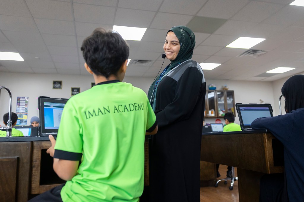 Science teacher Hend Mohamed helps a student at Iman Academy.