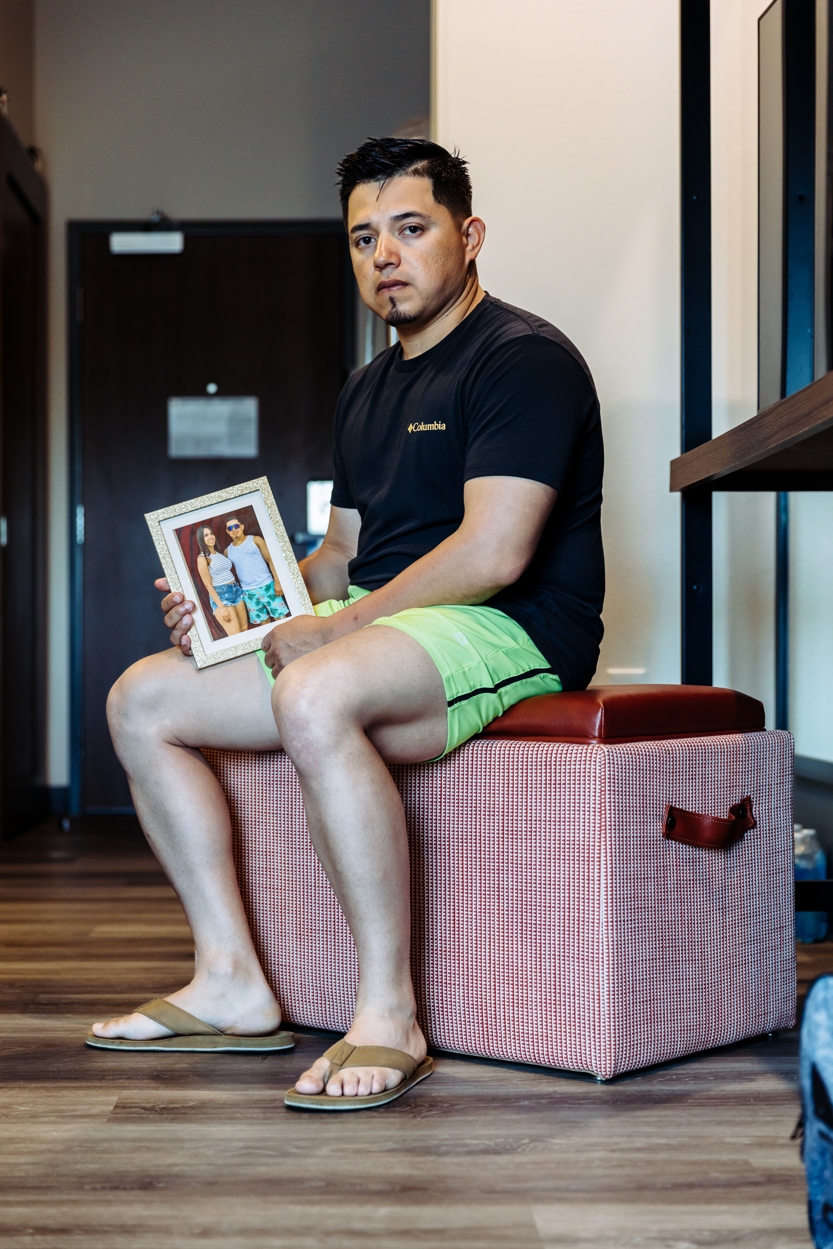 Juan Rodriguez sits in his hotel room at Everhome Suites in San Antonio while holding a framed photograph of his fianc&eacute;e, Johanny Carolina Lacruz Villalobos. Rodriguez said Lacruz Villalobos, a Venezuelan woman who entered the country through the CBP One app, was detained by ICE during their travel to San Antonio and is now being held at a detention facility in Raymondville.