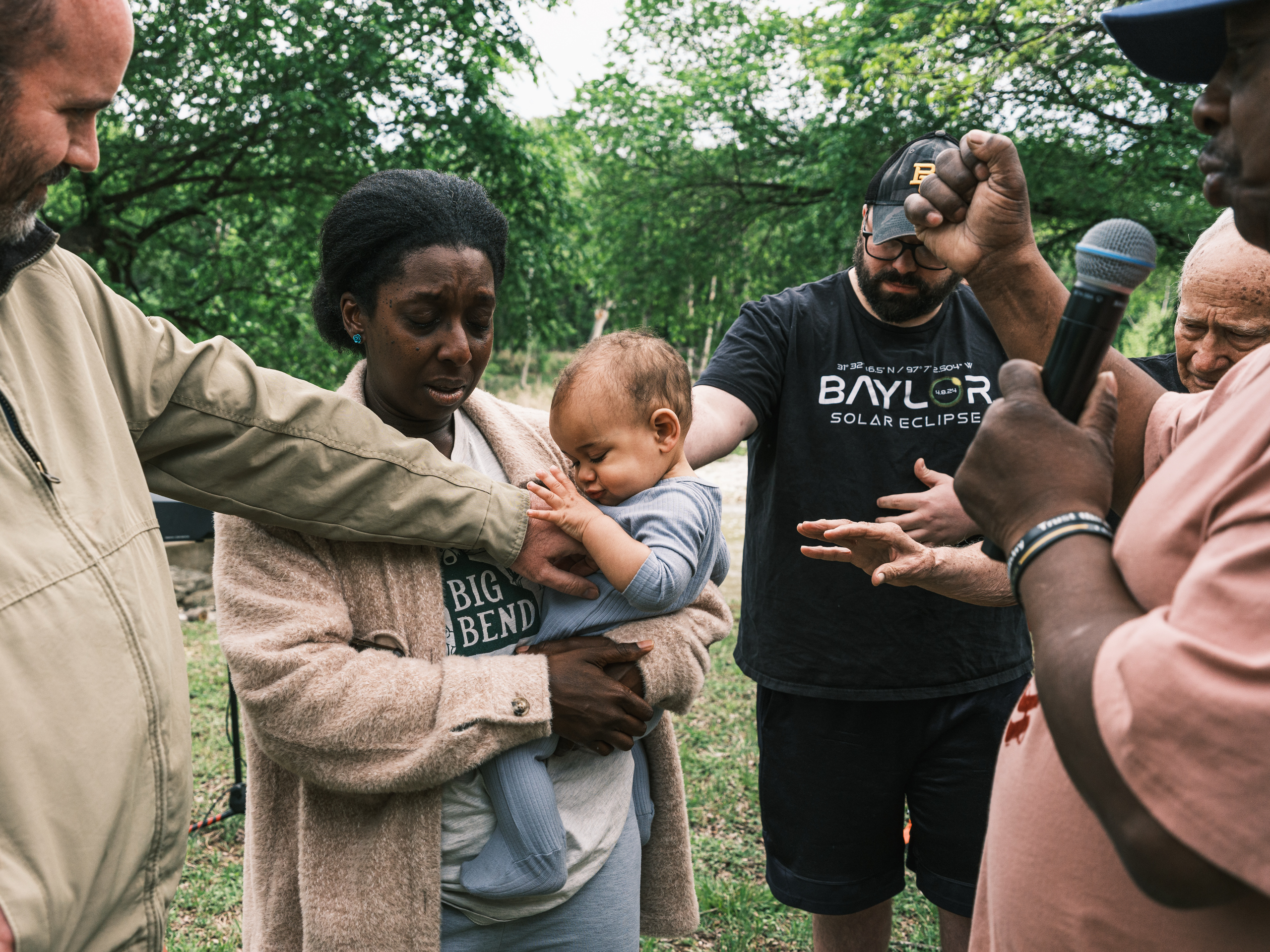 The congregation prays over the son of Philip and Hope Welch before the family is baptized in the Middle Bosque River.