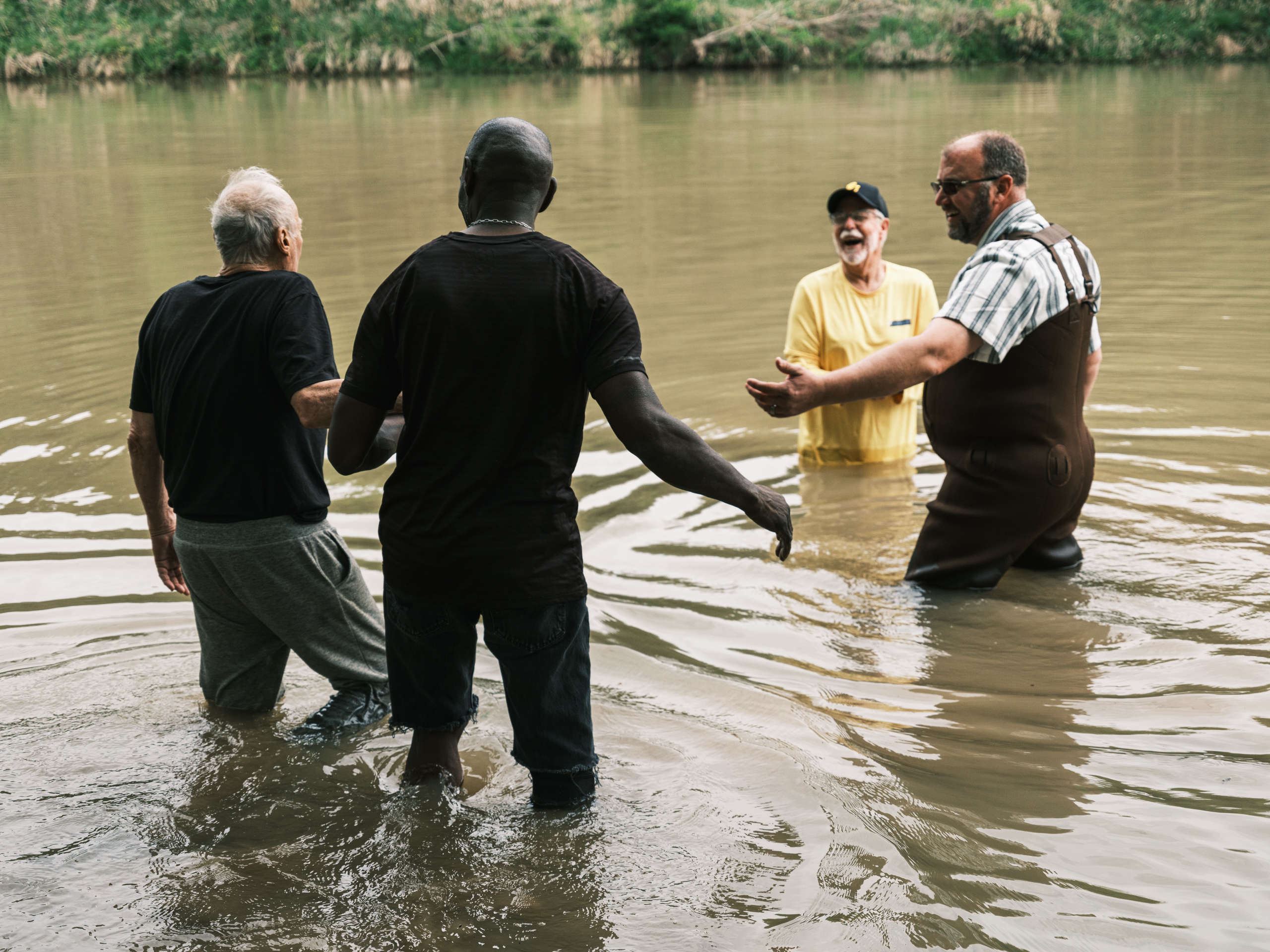 John Dokken is guided out into the Middle Bosque River to be baptized by Jimmy Dorrell and Kevin Brown during the Easter service.