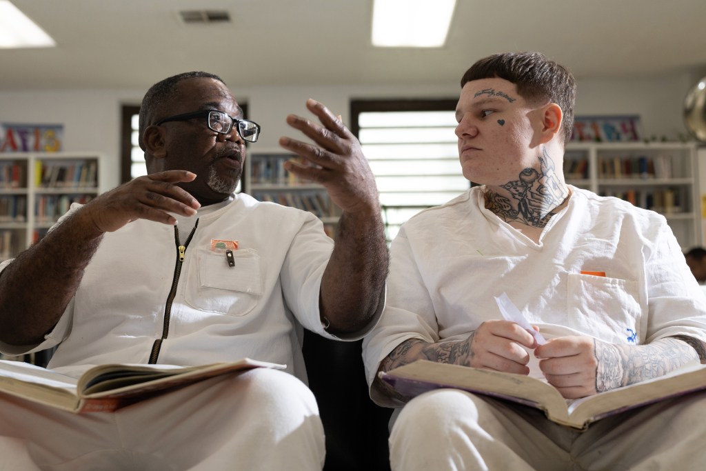 Freeman Arthur Brown, left, and Carroll Trent Dodson talk as they read through GED prep books in the library at the Wynne Unit in Huntsville.