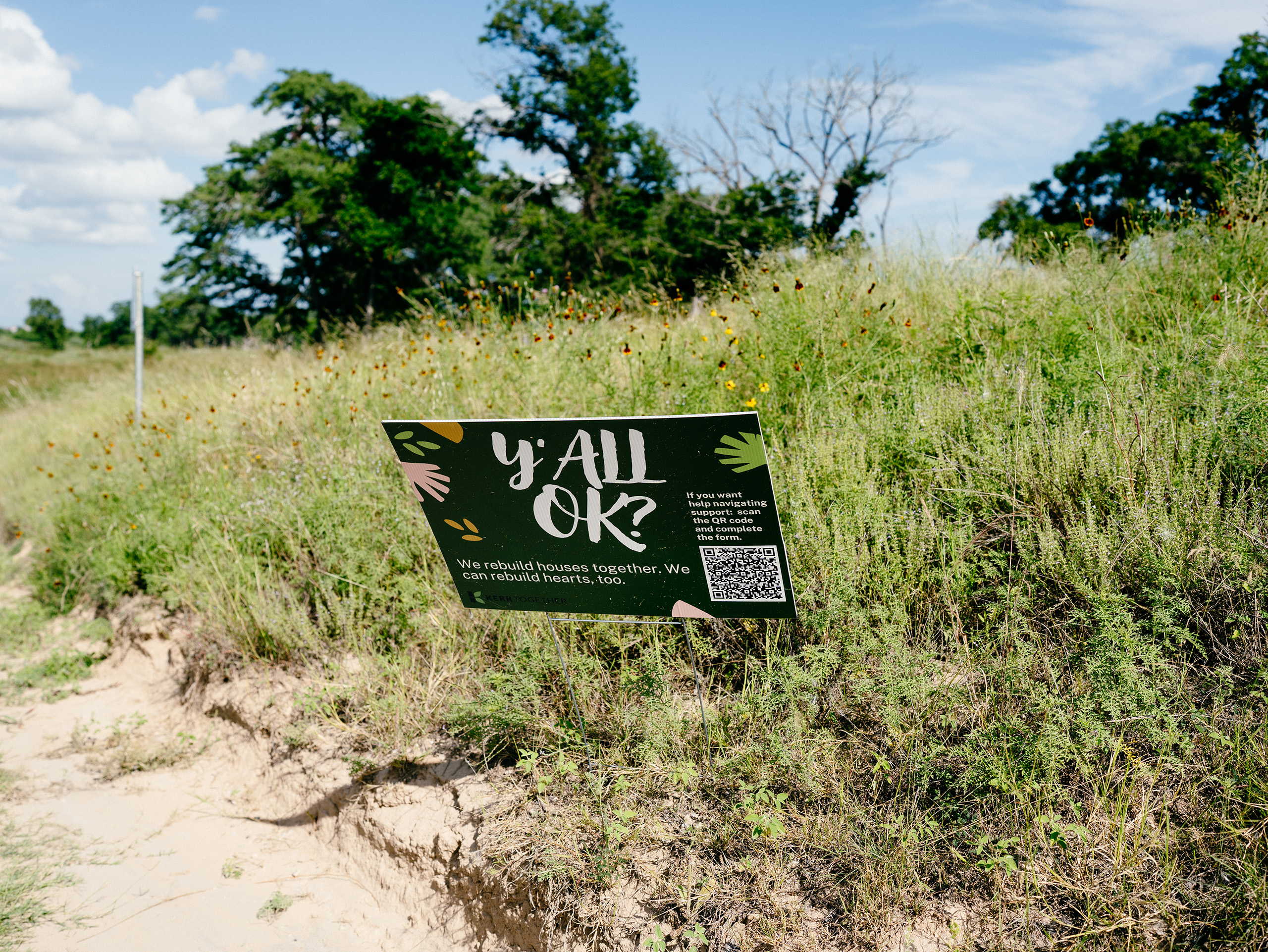 A sign on the side of the road in Center Point offers resources for flood relief.