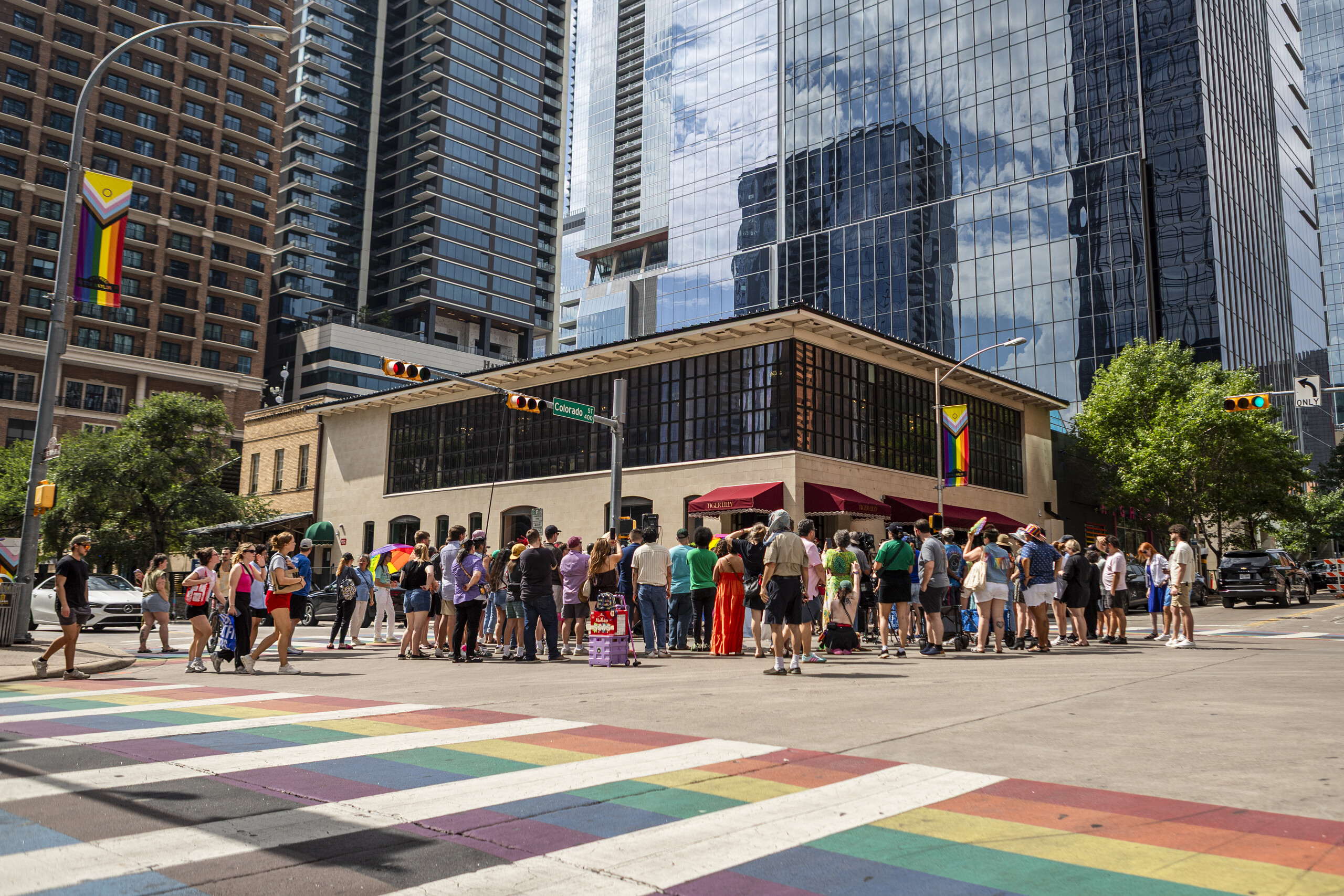 People gather around the newly installed mural on 4th street on June 20, 2026 in downtown Austin. The new mural sits near the rainbow crosswalk, which the city of Austin plans to scrap off by the end of July.
