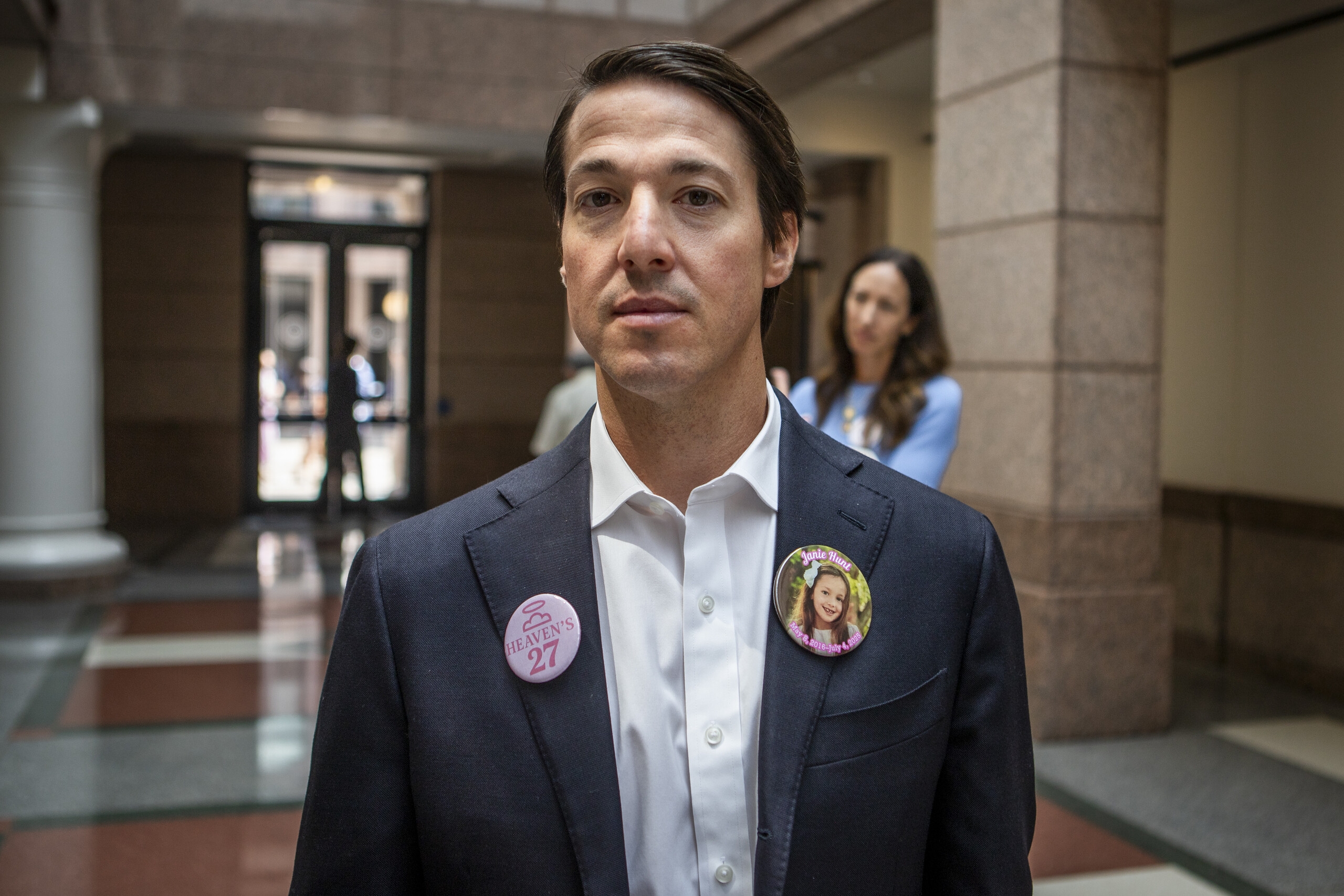 Davin Hunt, father of 9-year-old Janie Hunt who passed away during the Camp Mystic flood, poses for a portrait during a pause in the committee hearing intermission on Thursday. Hunt was one of several family members who wore pins in honor of their loved ones.