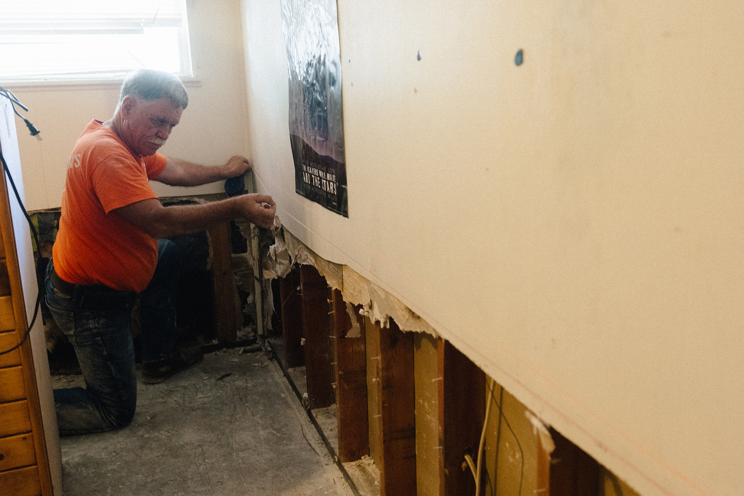 Mark Dalhoff , a volunteer with Samaritan’s Purse, chalks drywall to cut it due to water damage inside a home from the July 16 flood in Kerrville, Texas on July 28, 2026.