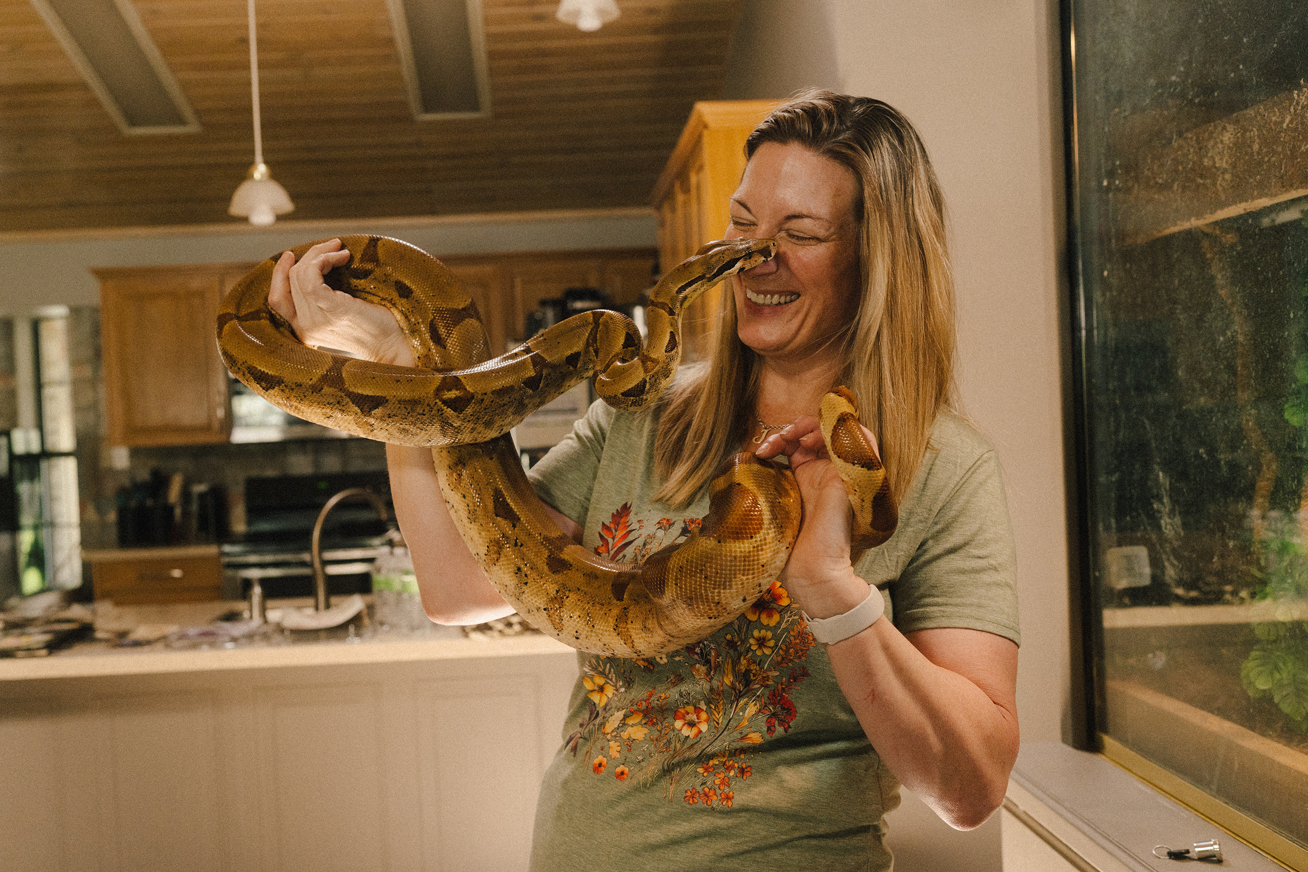Julie Casteel and her pet snake, a red boa constrictor, in Kerrville, Texas on July 28, 2026.