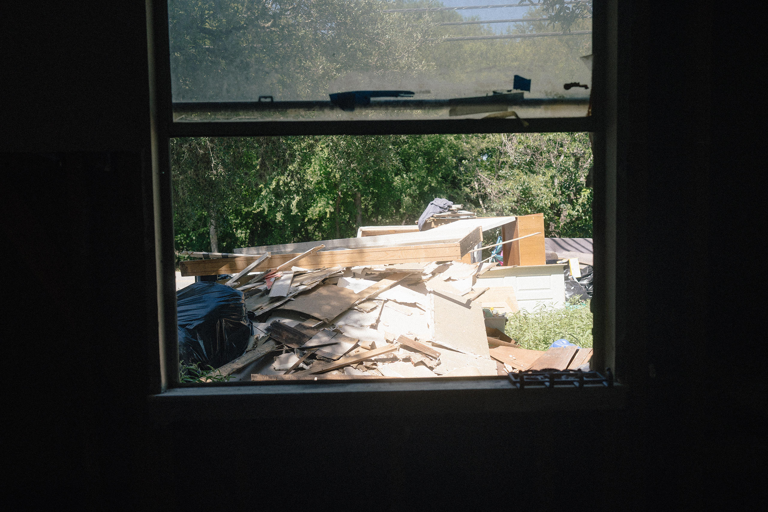 Furniture and other items from Michael Ybarra’s home that were damaged by the July 16 flood seen through a window in his home in Kerrville, Texas on July 28, 2026.