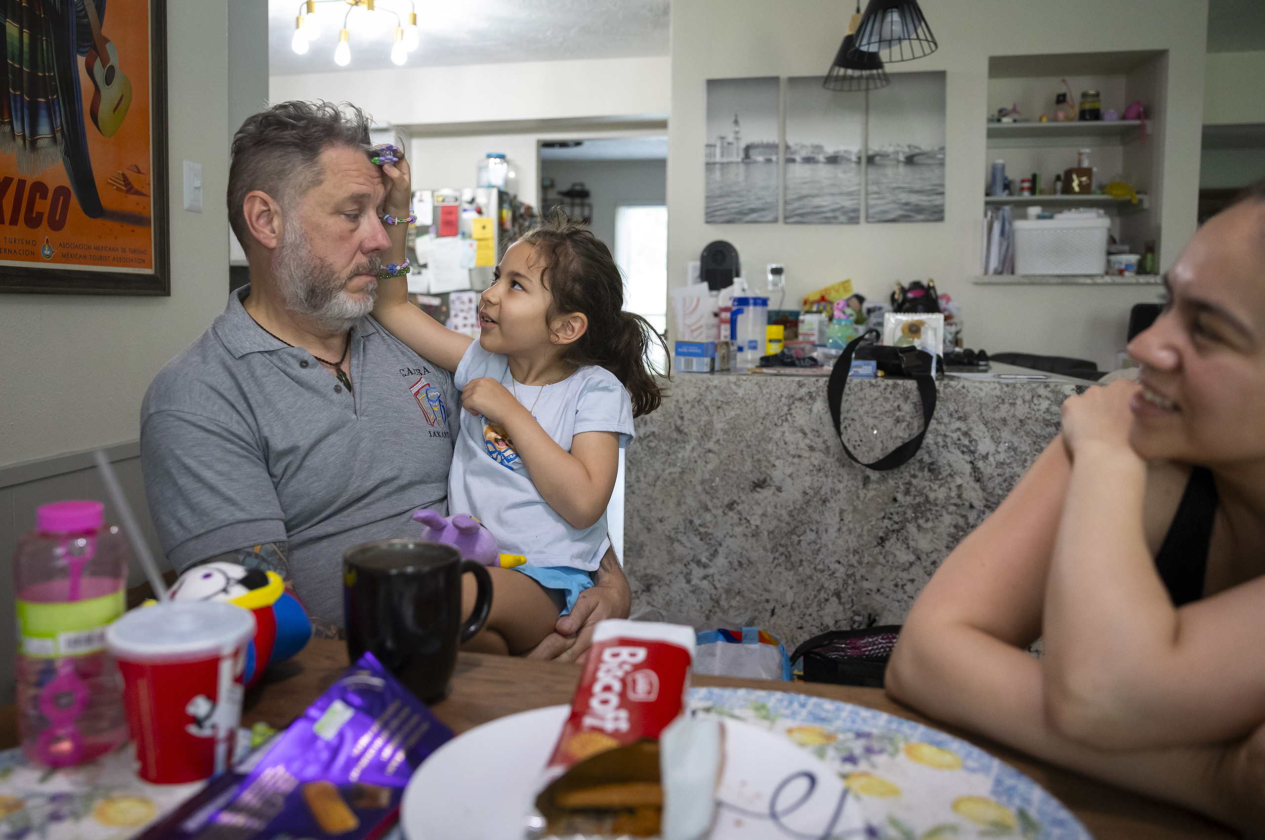 Darren Kemp sits with his daughter Dominika, 8, as the family shares afternoon tea in their north Houston home on June 14, 2026. The Kemps moved 20 miles north to continue their daughter’s education in Klein ISD after their HISD elementary school was switched to the NES model.