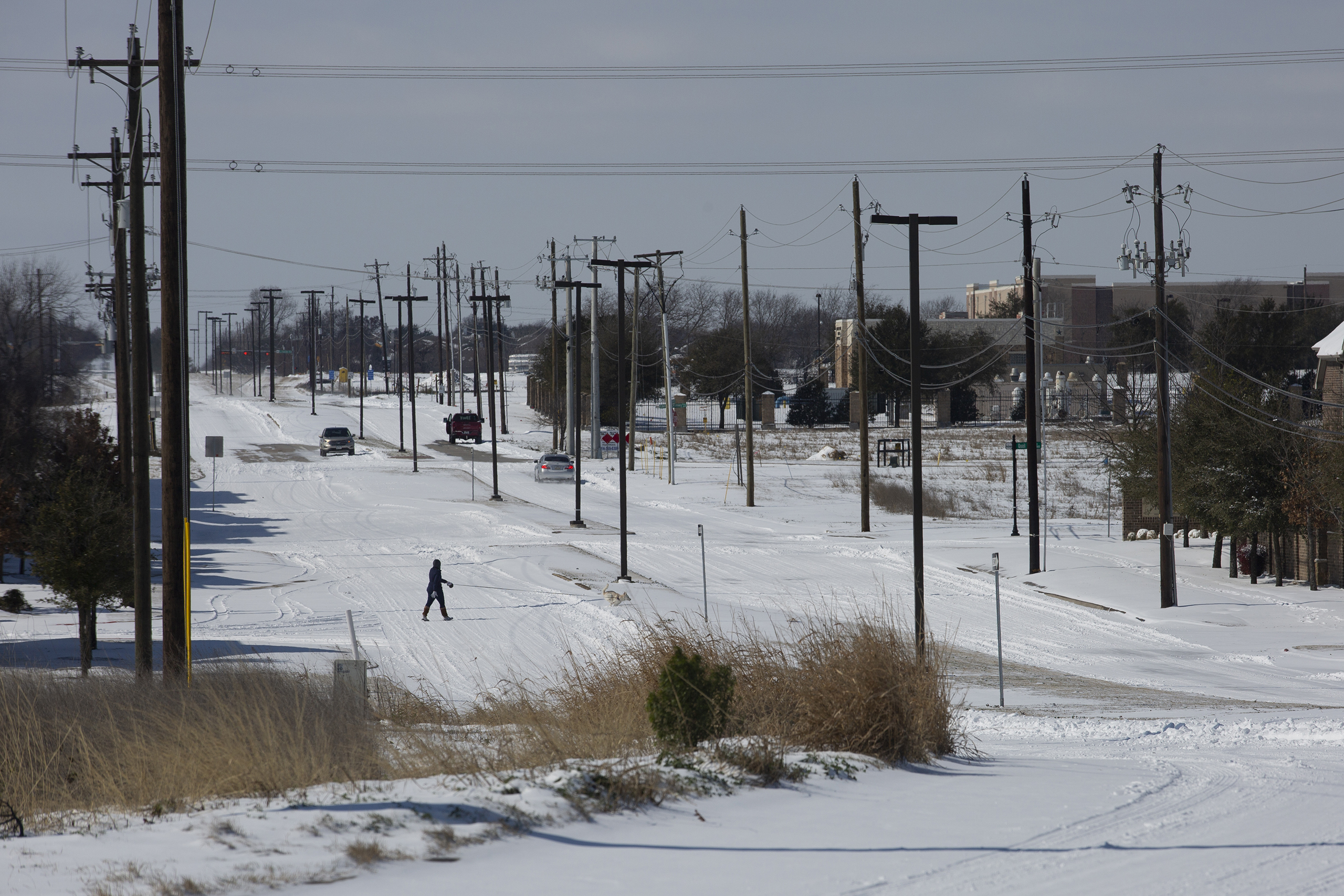 A pedestrian crosses snow-covered streets in McKinney during Winter Storm Uri on Feb. 15, 2021.